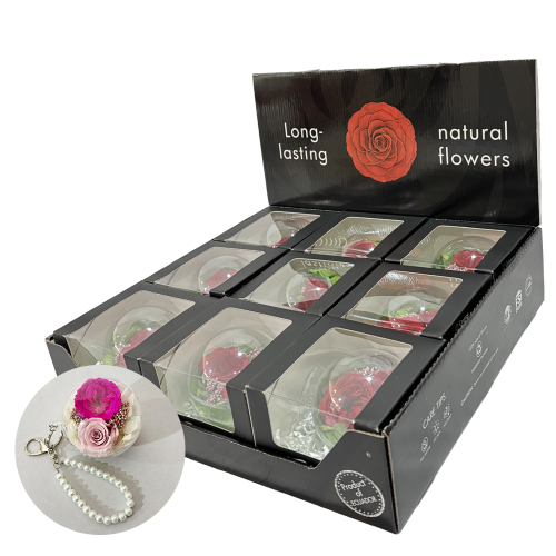 Display stand with black packaging reading 'Long-lasting natural flowers' and multiple clear-window gift boxes containing preserved roses; inset shows a pink rose with a pearl necklace.